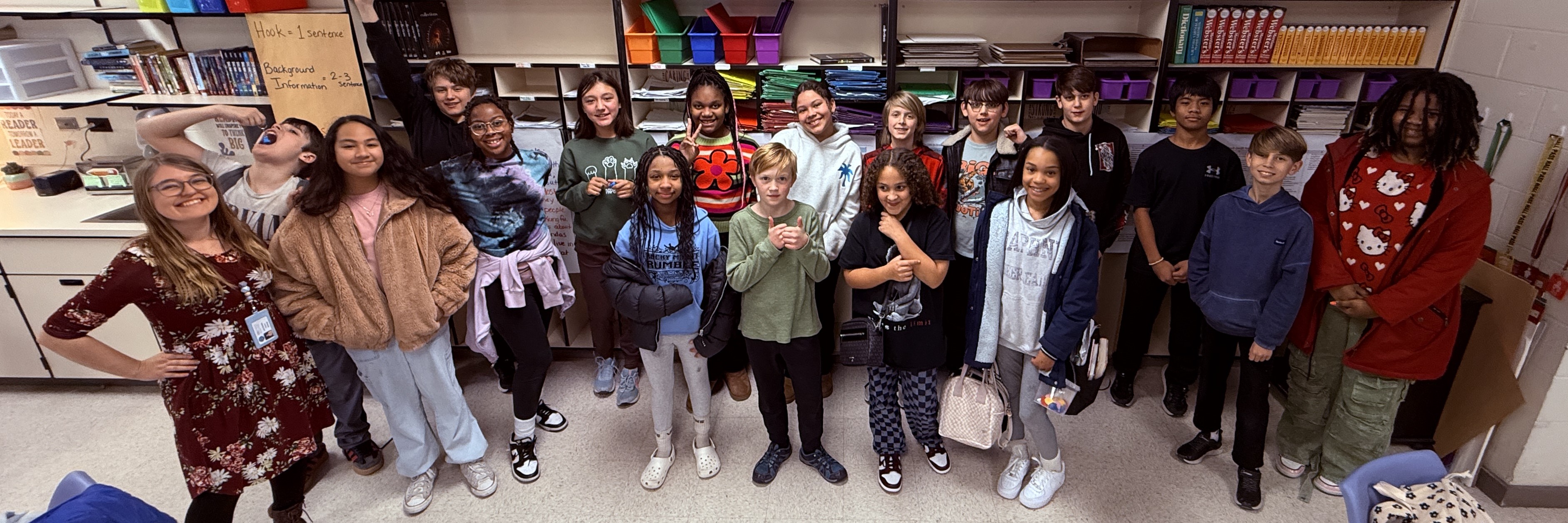 Students in front of a classroom wall.